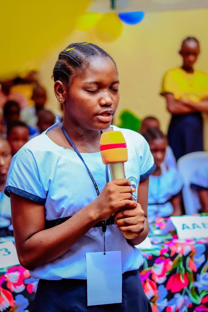 A BCP student speaks confidently into a microphone at a school event